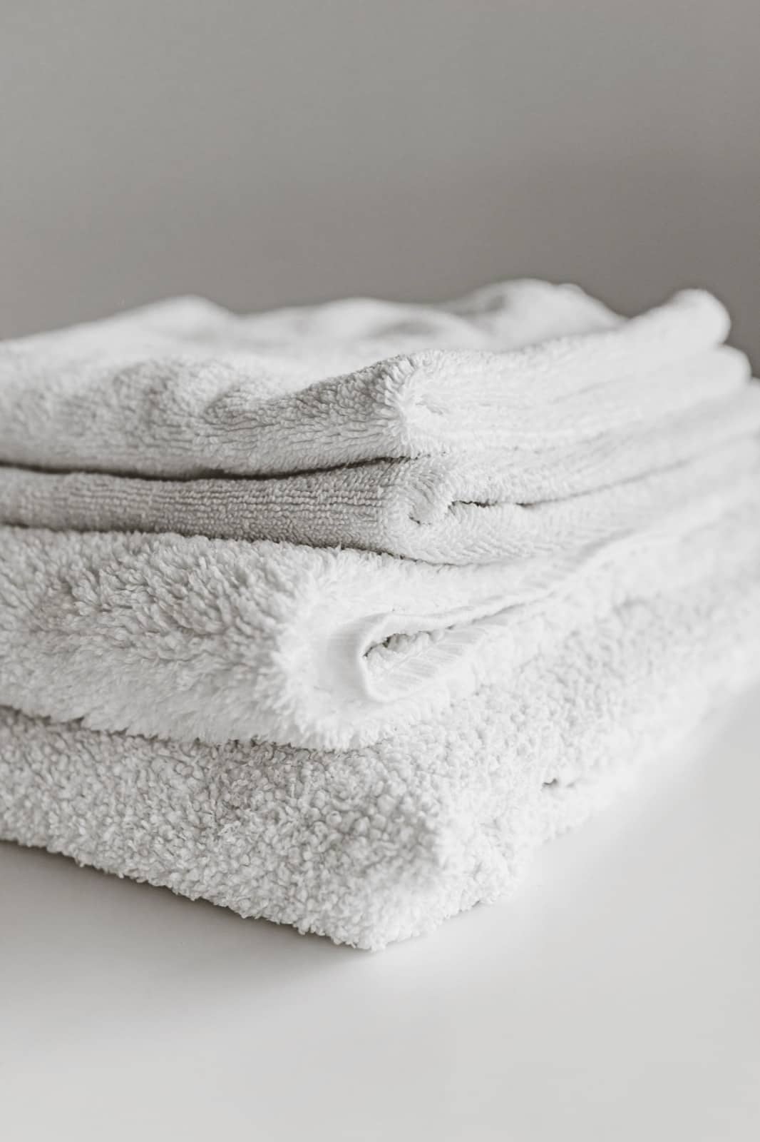 Fresh folded towels stacked and ready to restock a bathroom